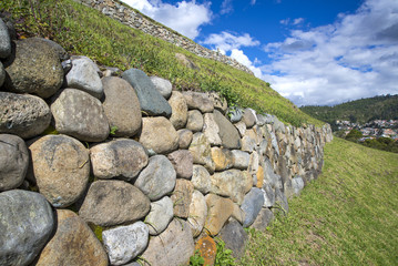 Stone walls of the ancient inca ruin city of Pumapungo, in Cuenca, Ecuador, on a sunny morning