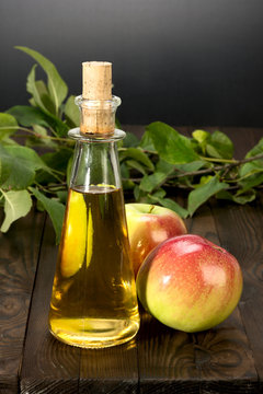 apple cider vinegar in a glass vessel and apples