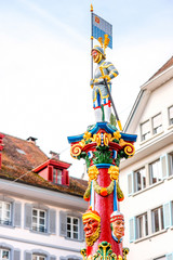 Fototapeta na wymiar Colorful old fountain statue on the Kapell square in the old town of Lucerne city in Switzerland