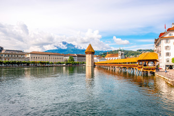 Cityscape view on the famous wooden bridge and tower on Reuss river in Lucerne old town in Switzerland