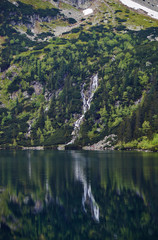 Mountain waterfall and Lake Morskie Oko in the Tatra Mountains in Poland