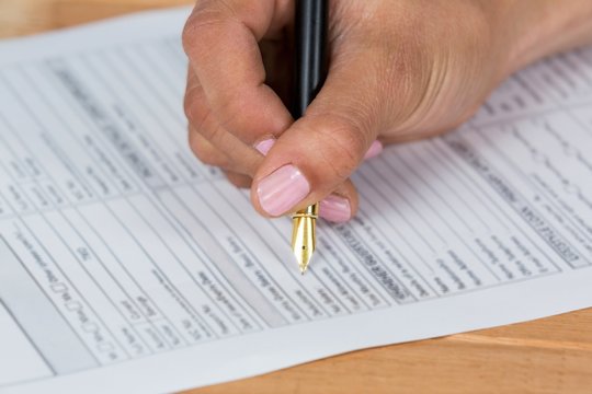 Businesswoman filling insurance contract form