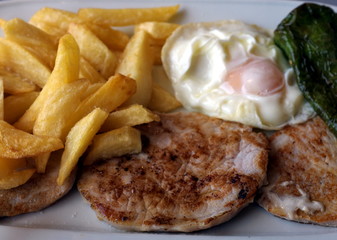 Frites, steack, oeuf poché, piment