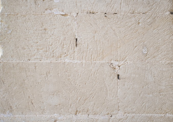 Traditional white stone wall. Detail of a wall made of white limestone bricks. Visible traces of...