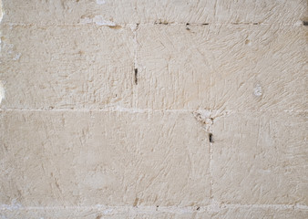 Traditional white stone wall. Detail of a wall made of white limestone bricks. Visible traces of chisel.