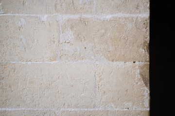 Traditional white stone wall. Detail of a wall made of white limestone bricks. Visible traces of chisel.