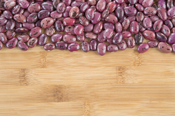 Pinto beans on the wooden background. (Phaseolus vulgaris)