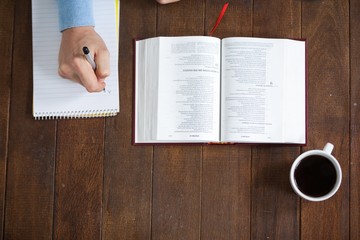 Man with a bible writing on notepad