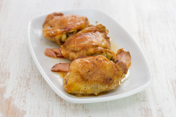 fried chicken with smoked meat on white plate on wooden background