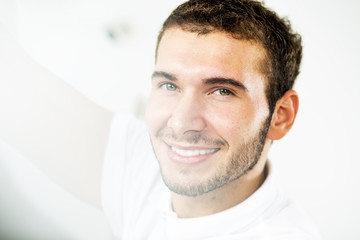 Obraz premium Young handsome man. Pretty young guy looking throw window. Close up. Profile.