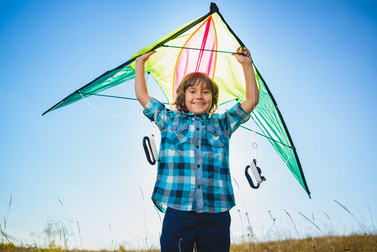 Happy and smiling boy playingin with kite outdoor
