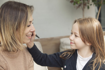 Mother and daughter playing with makeup.