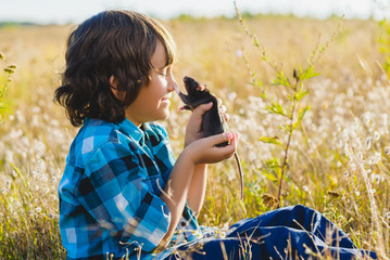 teenage happy boy playing with rat pet outdoor