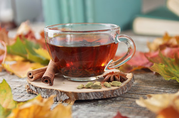 tea cup and autumn leaves on a wooden background