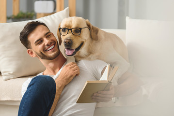 smiling man sitting with labrador