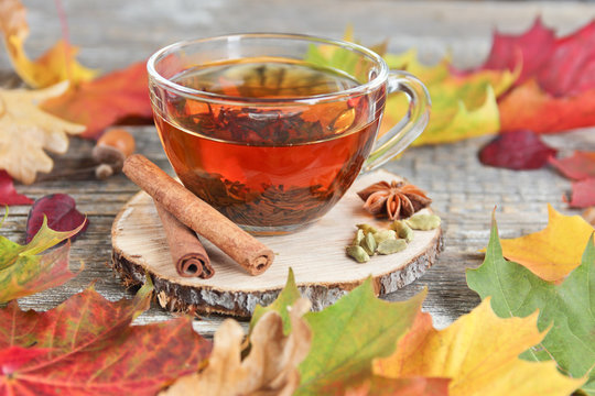 tea cup and autumn leaves on a wooden background