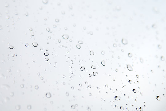Monochrome blurred drops background.Rainy window.