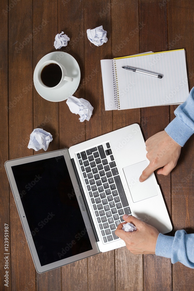 Poster Man using laptop while writing on notepad