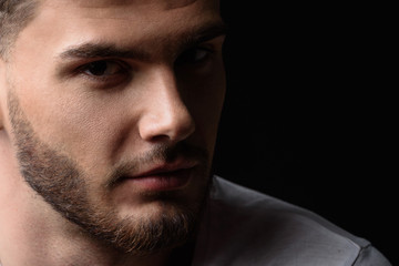 Obraz premium face of a man looking into the camera from darkness