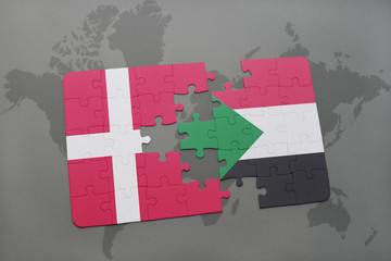puzzle with the national flag of denmark and sudan on a world map background.