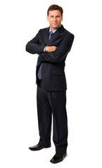 Full-length businessman in dark suit with arms crossed isolated on white background