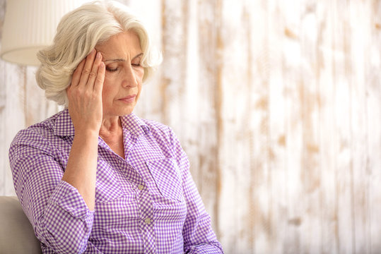 Frustrated old lady has pain in head