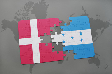 puzzle with the national flag of denmark and honduras on a world map background.