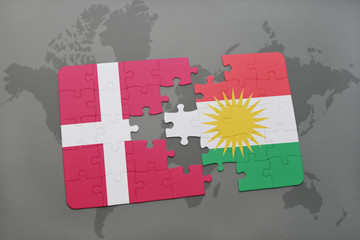 puzzle with the national flag of denmark and kurdistan on a world map background.