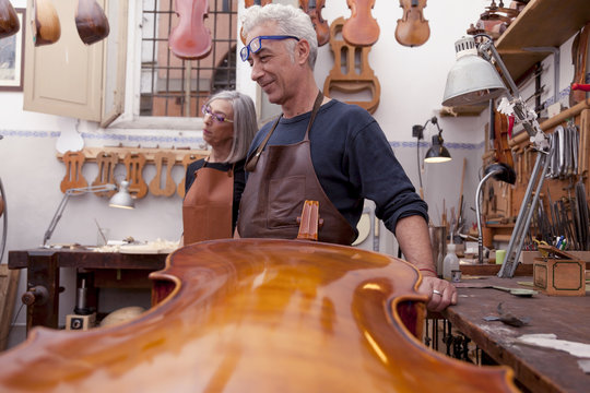 portrait of mature violin maker while testing the violins in his