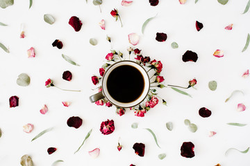 black coffee mug and red rose buds bouquet with eucalyptus on white background. flat lay, top view