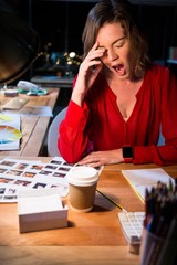 Stressed businesswoman yawning at her desk
