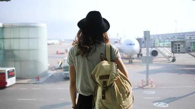 girl standing at the window in airport terminal.