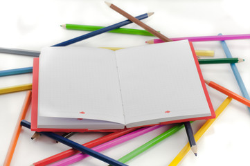 Colored notebook and pencils on white background