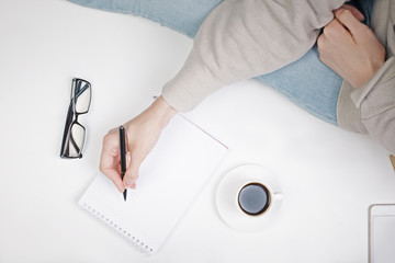 Girl's hand writing in notepad