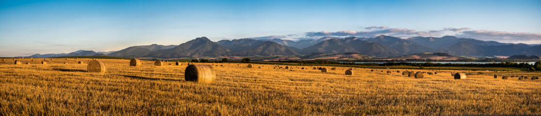 Harvested Field with Hay Bales in Golden Evening Light Under Low Tatras Mountains, Slovakia