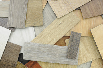 Laminate Wood Concept -  Samples of laminate and vinyl floor tile on wooden Backgroun