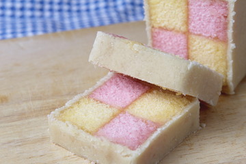 Freshly cut Battenberg Cake with pink and yellow sponge covered in marzipan