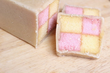 Freshly cut Battenberg Cake with pink and yellow sponge covered in marzipan