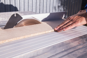 man cutting wood with saw blade