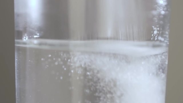 Sport supplement, creatine, hmb, bcaa, amino acid or vitamin - scoop with some powder over a glass of water. Sport nutrition or health concept.
