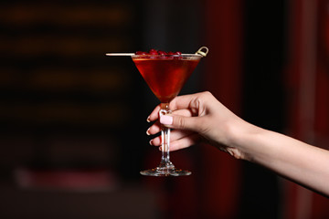 Woman hand holding tasty long drink in bar