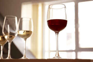 Glasses with red and white wine on table in restaurant