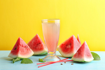 Homemade refreshing drink in glass and watermelon slices on table
