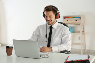 Handsome man listening to music with headphones at office