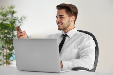 Handsome young man using cellphone at office