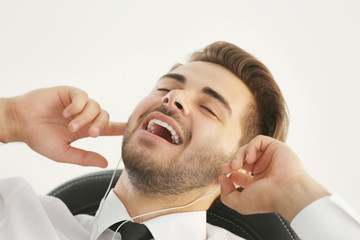 Handsome young man listening to music with headphones at office