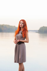 Outdoors portrait of beautiful smiling woman with red hair