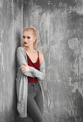 Fototapeta premium Pretty young blonde woman in casual clothes against grunge background