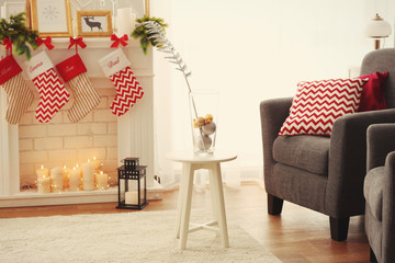 Stool with glass vase in living room decorated for Christmas
