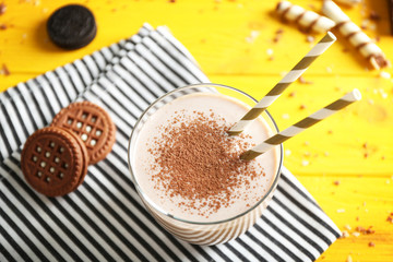 Delicious milkshake with cookies on napkin closeup